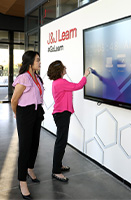 Year in Brief - Employees - learn, Johnson & Johnson female employees in front of interactive screen (photo)