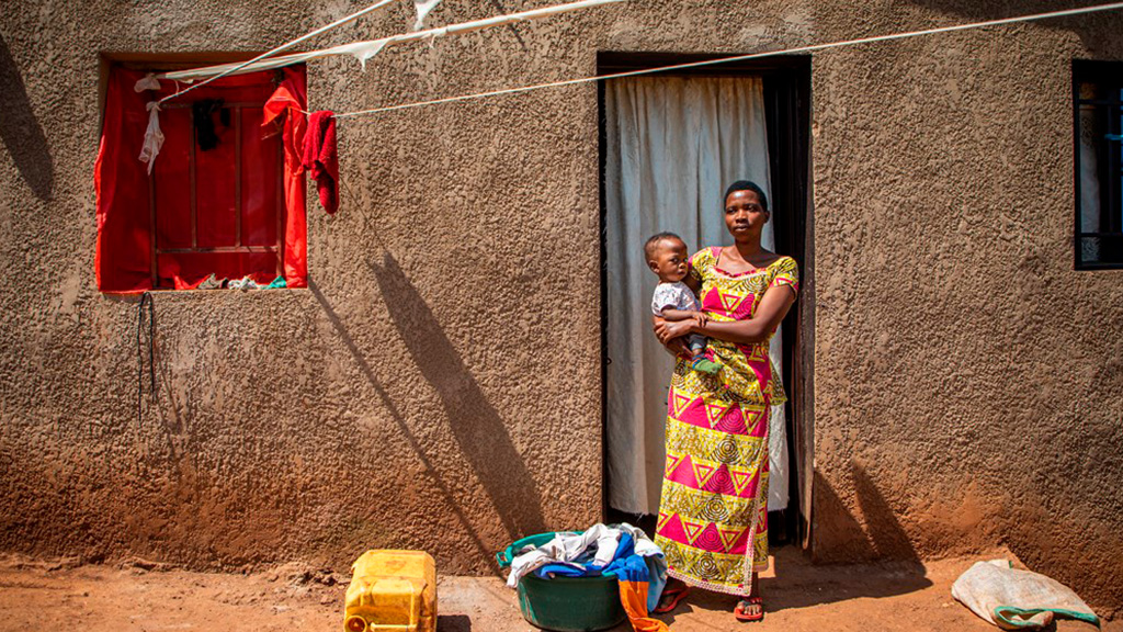 The family member of a patient of Caraes Ndera Neuropsychiatric Hospital stands outside her home in Kigali, Rwanda. Credit: Will Swanson for Devex. (photo)